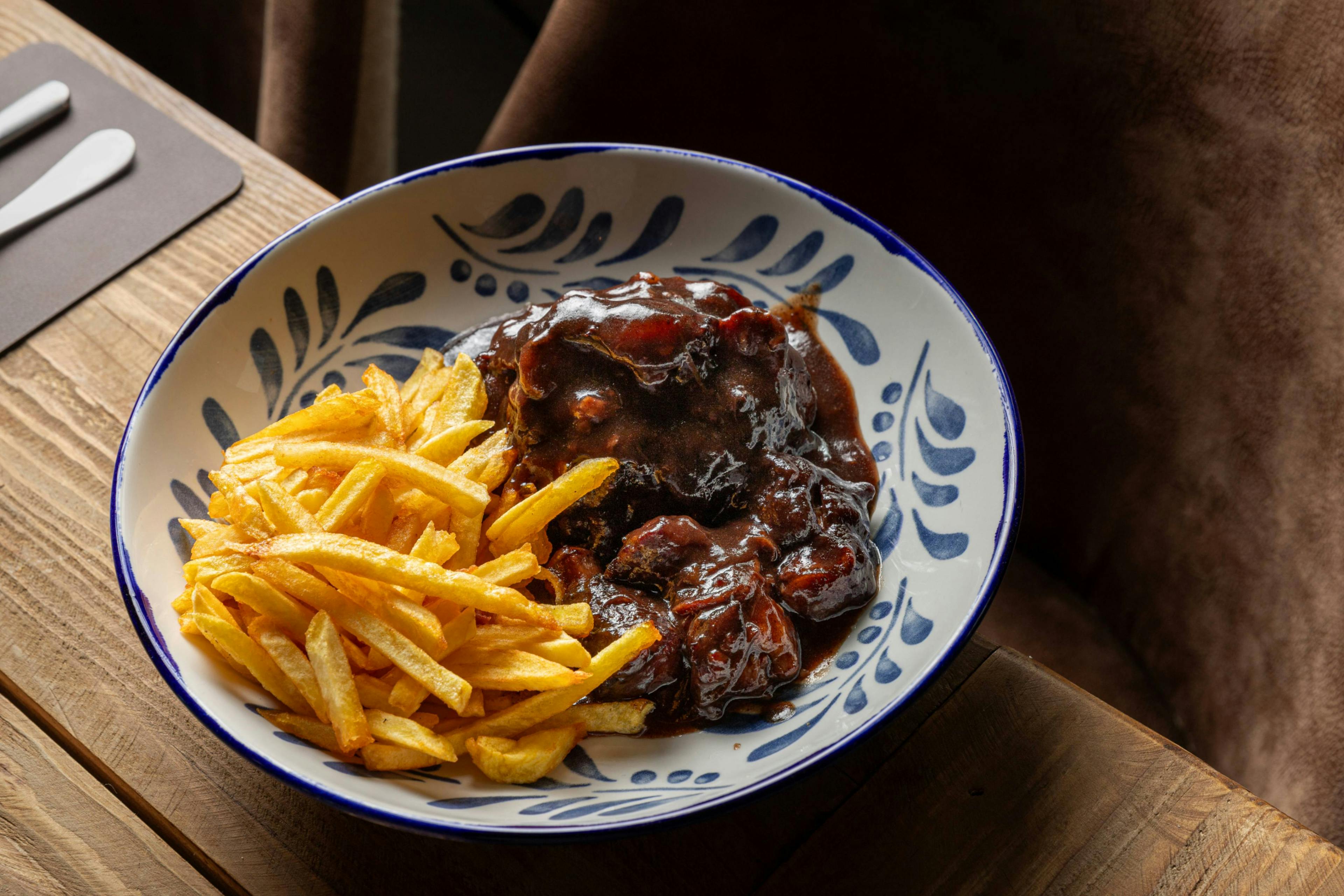 Rabo de toro estofado al vino con patatas fritas